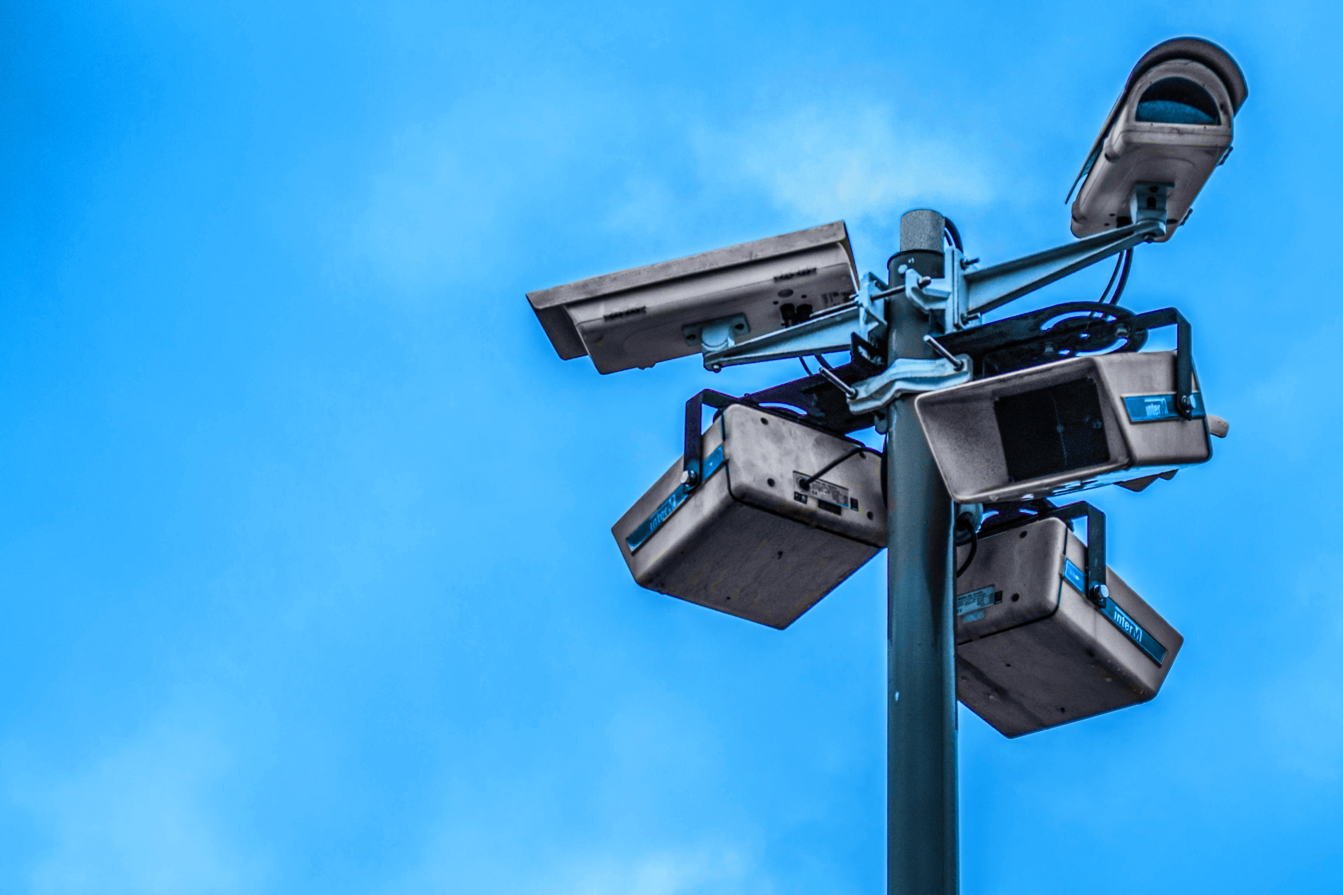 Securty cameras on a pole against a blue sky